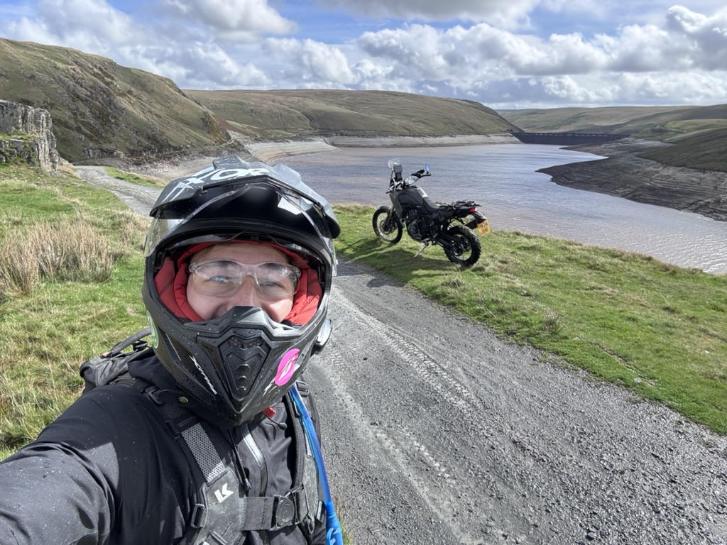 Peter on a motorbike trip beside a mountain reservoir